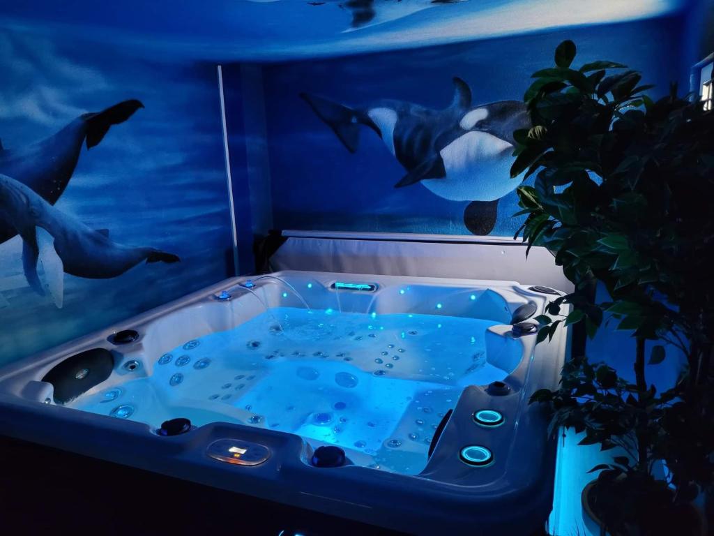 a bath tub with dolphins painted on the wall at Effet Mer, 4 etoiles, gîte de 80m2 in Dorlisheim