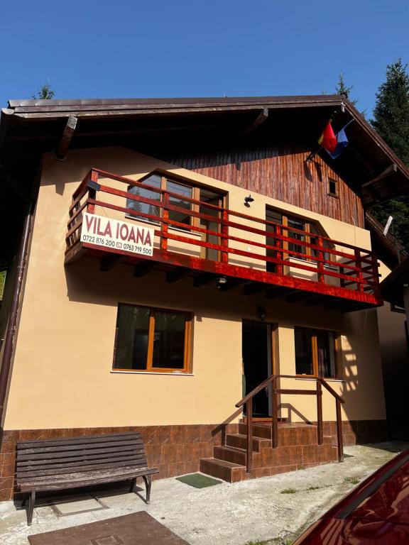 a building with a balcony and a sign on it at Vila Ioana in Râu de Mori