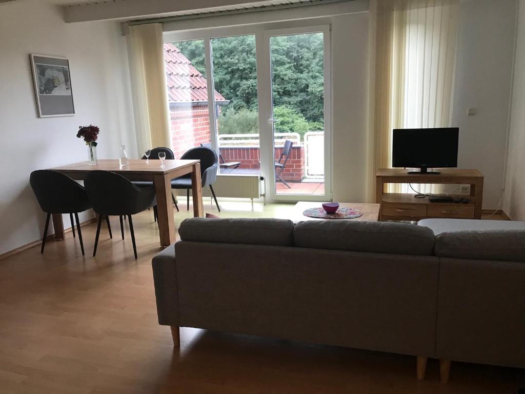 ein Wohnzimmer mit einem Sofa und einem Tisch in der Unterkunft Ferienwohnung Thedo in Bad Zwischenahn