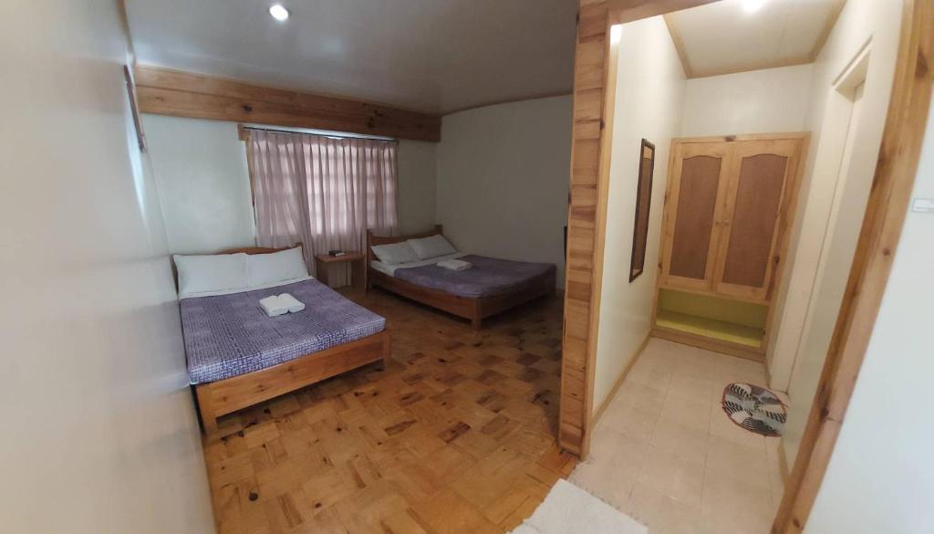 um pequeno quarto com uma cama e um sofá em Rusty Nail Inn and Cafe em Sagada