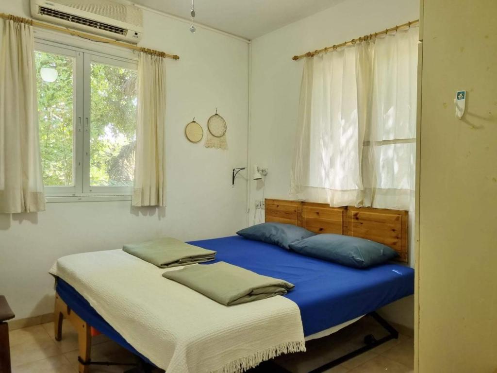 1 dormitorio con 2 camas y ventana en בית פרומן, en Moledet