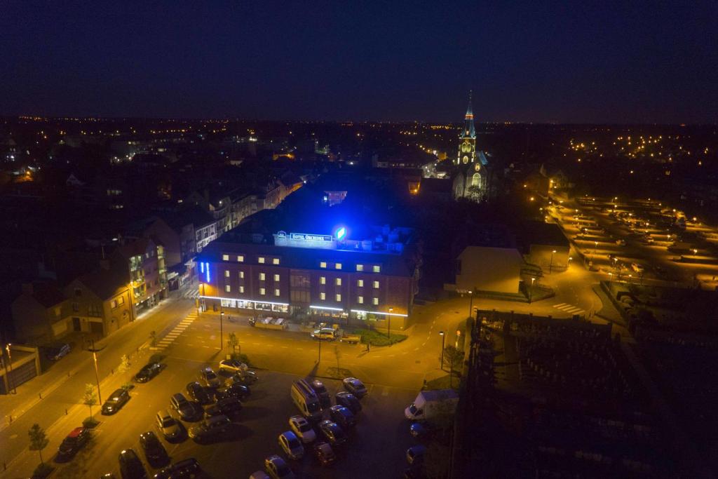 een uitzicht op een stad in de nacht met een gebouw bij Hotel Orchidee in Aalter