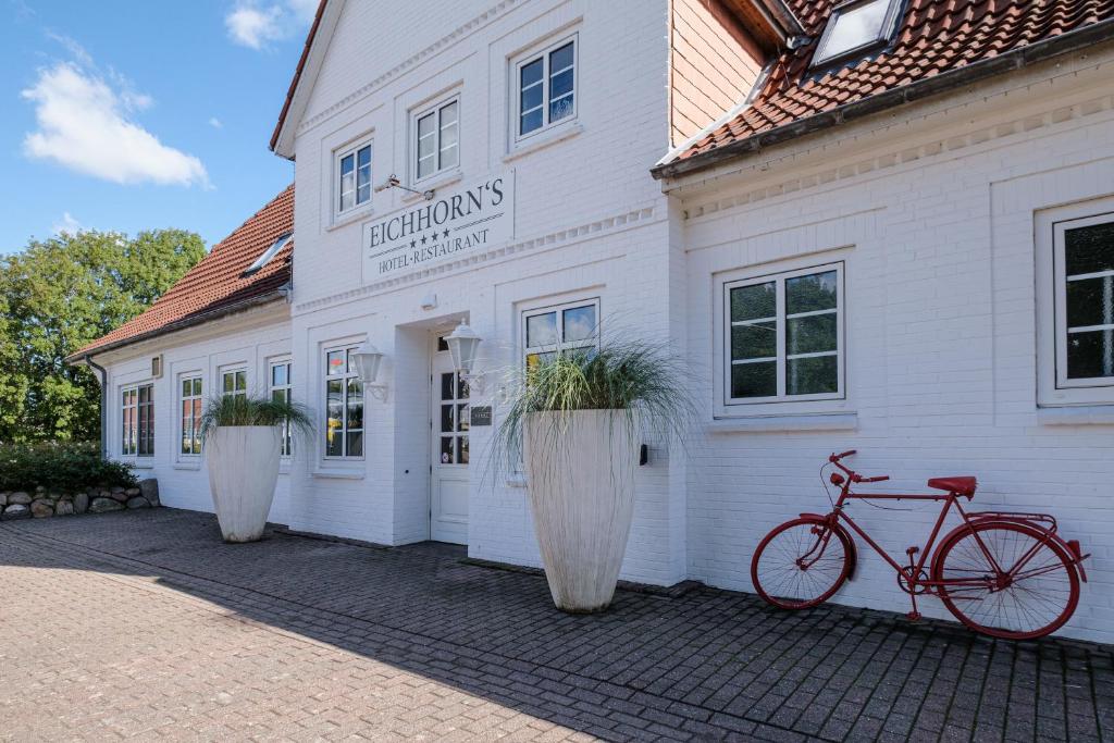 una bicicleta estacionada frente a un edificio blanco en Eichhorns en Niebüll