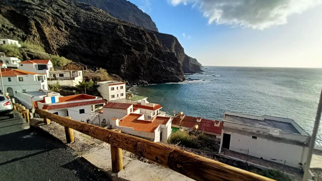 a village on the side of a mountain next to the ocean at alquilaencanarias Casa La Playa La Gomera in Alojera