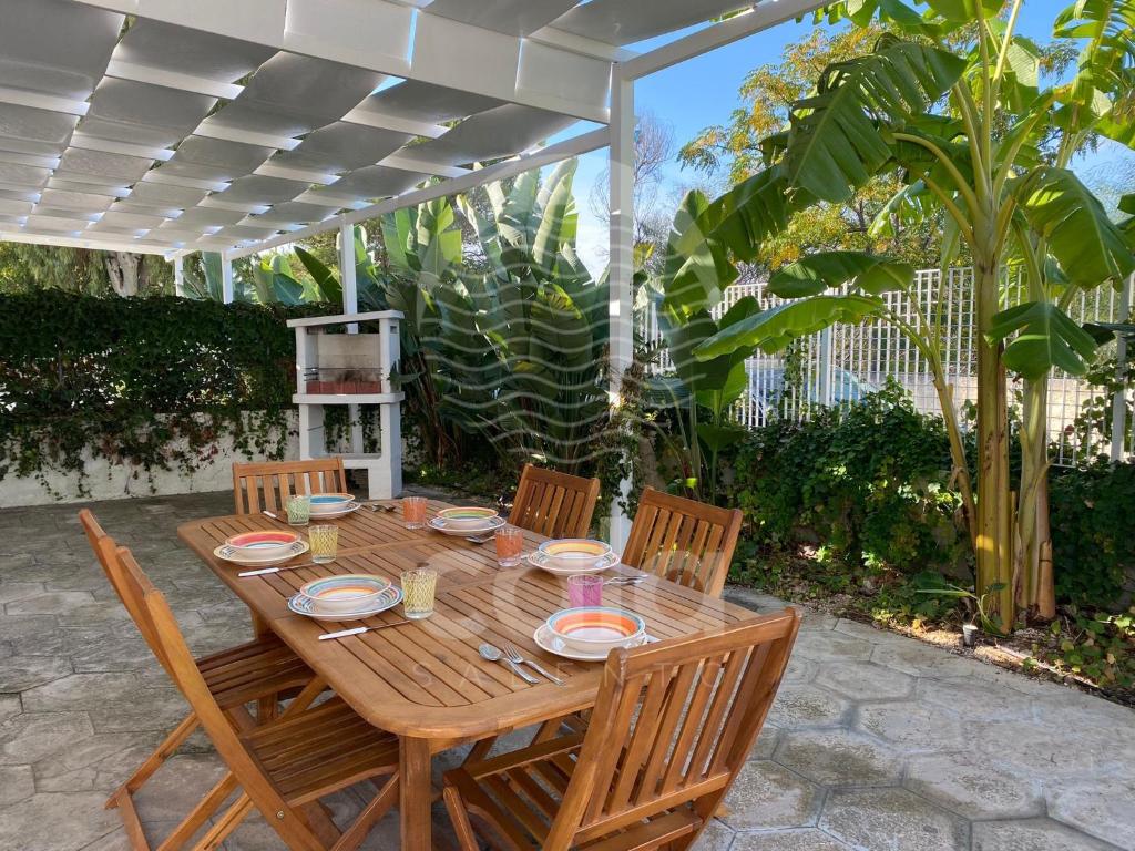a wooden table with four wooden chairs at Villa Tortuga By Cala Salento in Torre Lapillo