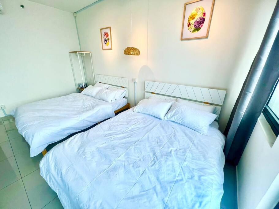 two beds sitting next to each other in a room at D 1-5Pax Cozy Home Trefoil Setia Alam 3bed Wifi &TV Shah Alam Setia City Mall in Setia Alam