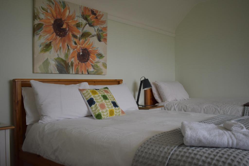 1 dormitorio con 2 camas y un cuadro en la pared en Fourwinds B&B, en March