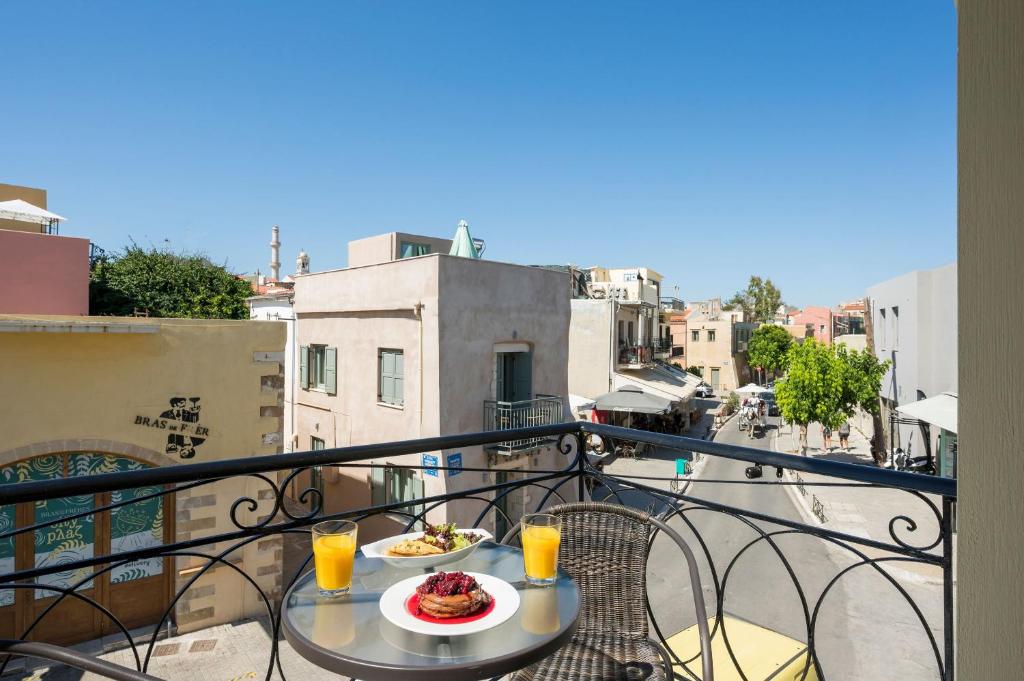 a table with a plate of food on a balcony at Porto Orion Studios in Chania Town