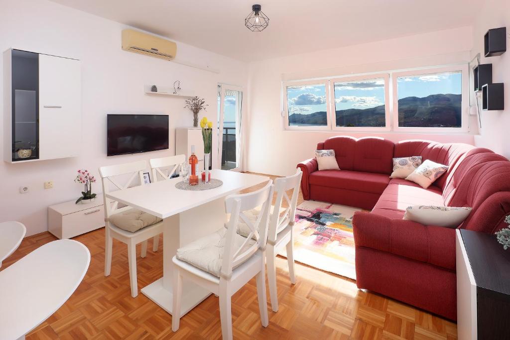 een woonkamer met een rode bank en een tafel bij Apartment Leon - Sea View in Rijeka