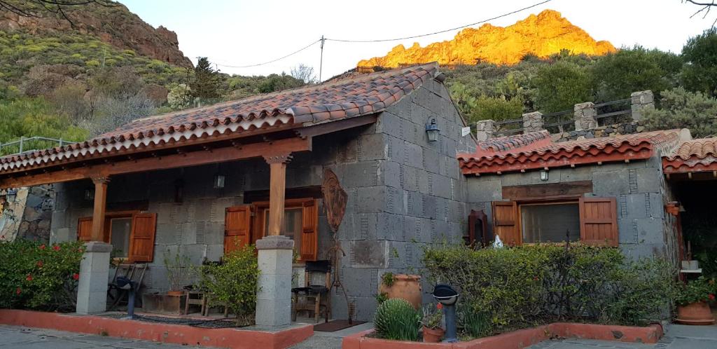 une petite maison avec une montagne en arrière-plan dans l'établissement Hoya La Vieja Rural, à Tejeda