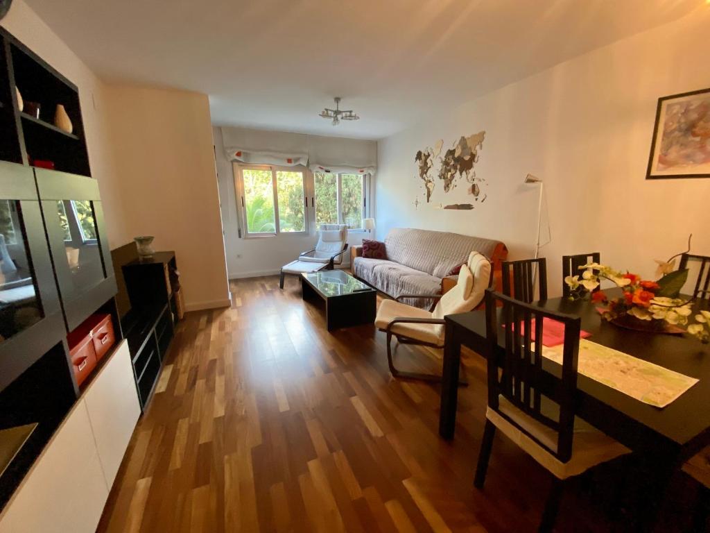 ein Wohnzimmer mit einem Sofa und einem Tisch in der Unterkunft Mike´s apartment. Parking y piscina in Granada