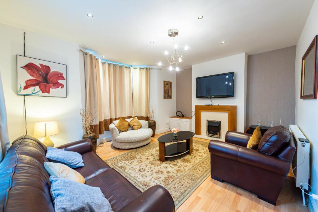 a living room with a leather couch and a tv at The Chestnut - Liverpool City - L7 in Liverpool