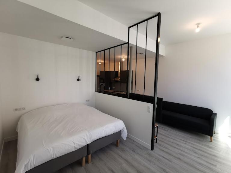 een slaapkamer met een bed en een grote spiegel bij 10 rue Carnot in Montceau-les-Mines