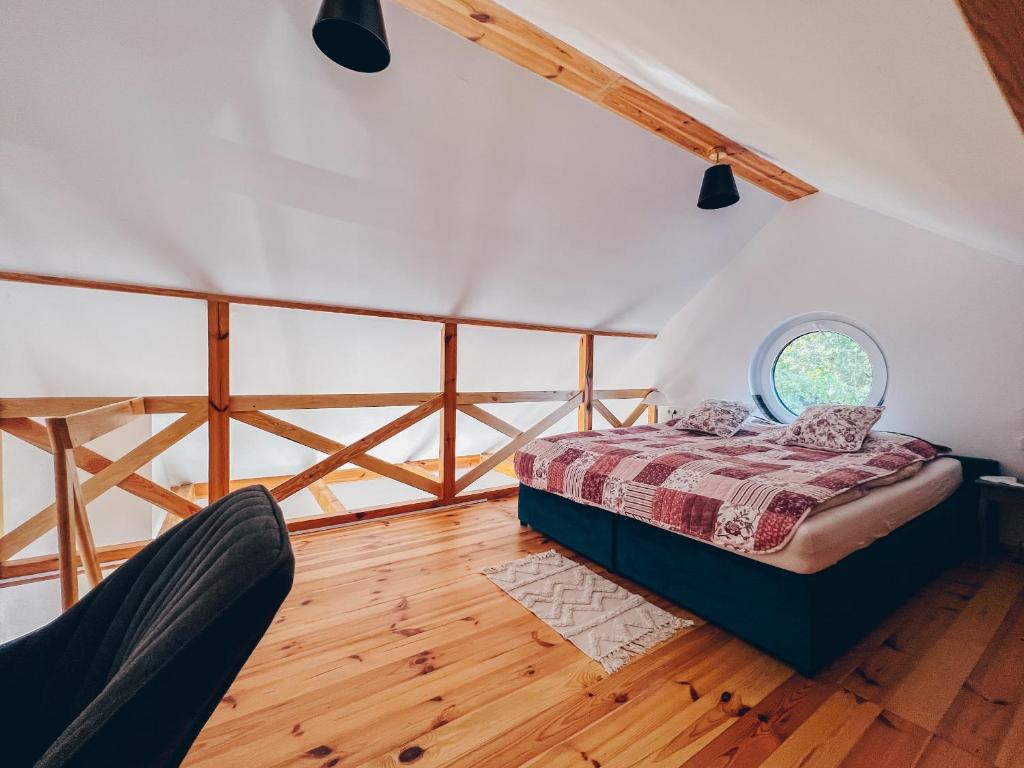 a bedroom with a bed and a round window at Lipolas-slowlife&guesthouse in Jurków