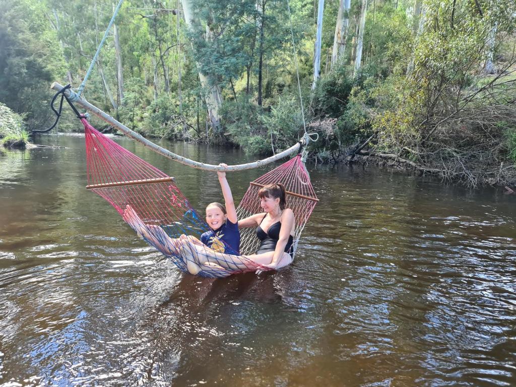 a woman and a child in a hammock in a river at The Hammock 