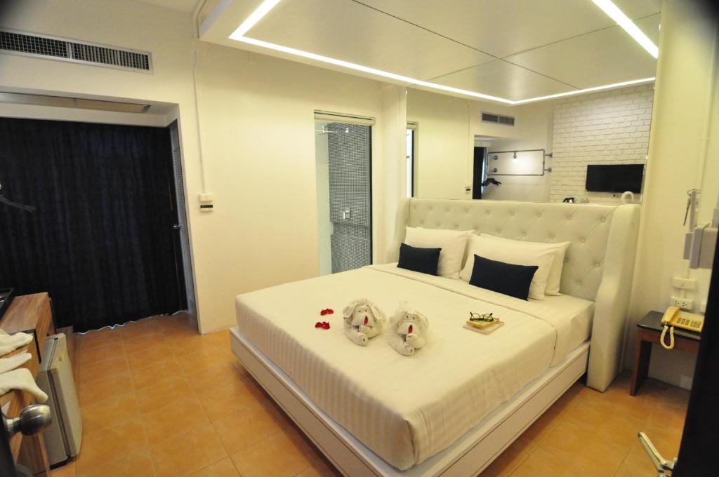 Postel nebo postele na pokoji v ubytování Forty Winks Phuket Hotel