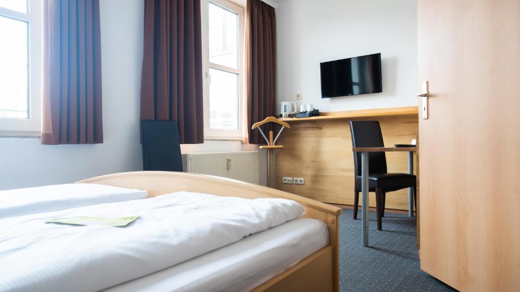 a hotel room with a bed and a desk at Hotel Am Hopfenmarkt in Rostock