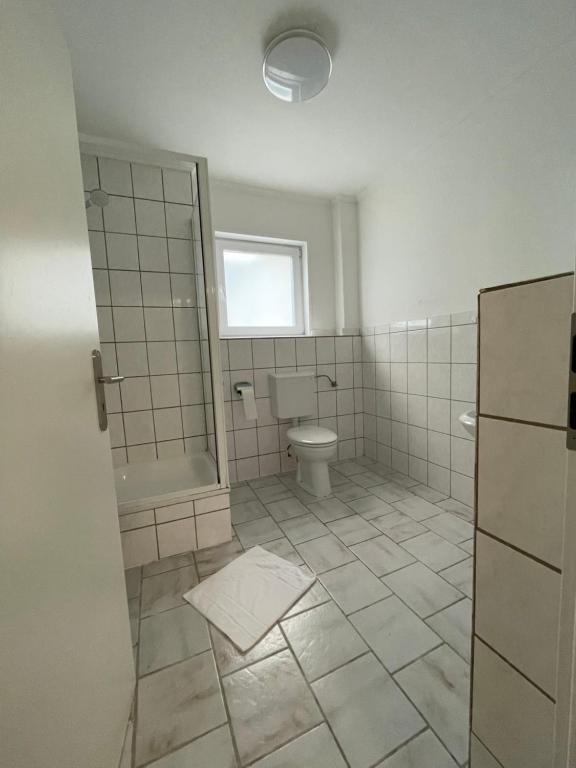 a bathroom with a toilet and a window at Tyros Hotel und Gästehaus am Weidendamm in Hannover