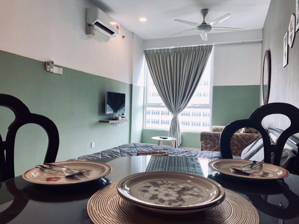 a dining room with a table and chairs and a room with a window at Summer Suites in George Town