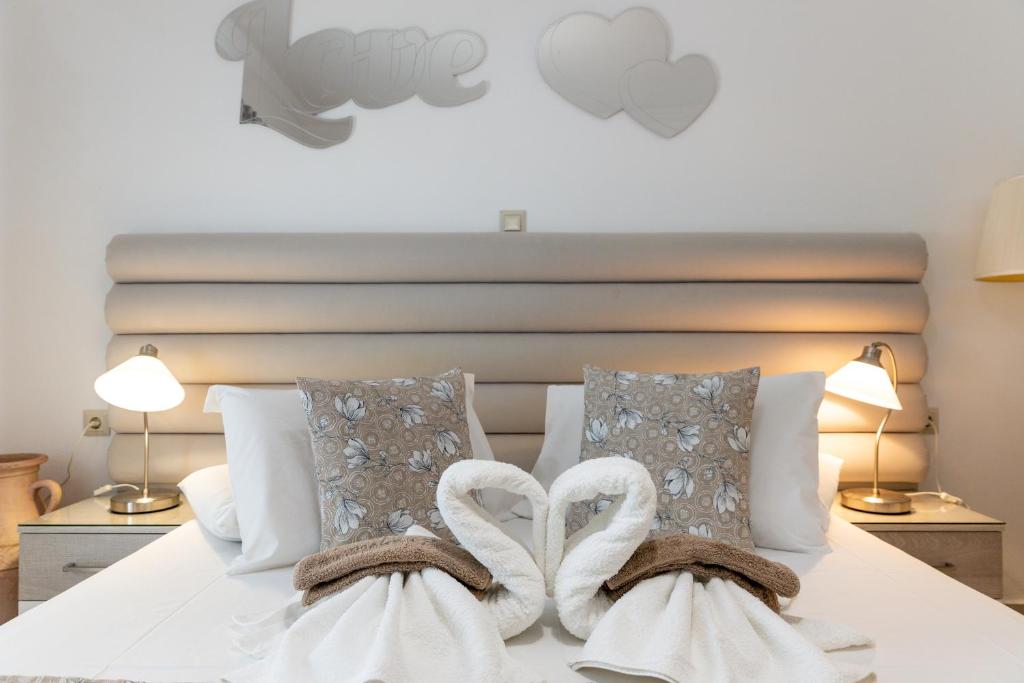 sypialnia z łóżkiem z białą pościelą i poduszkami w obiekcie Panos Luxury Studios w mieście Parikia