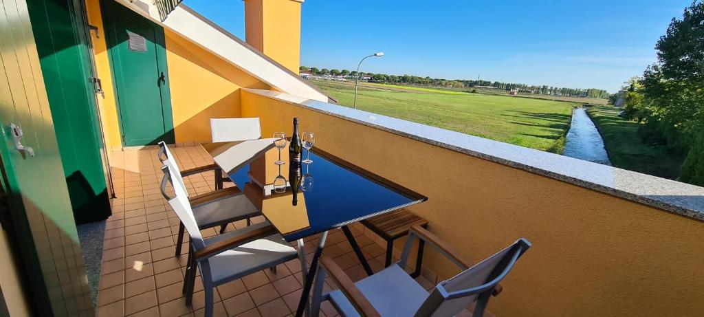 a balcony with a table and chairs and a river at Adria Beach Apartment in Cavallino-Treporti