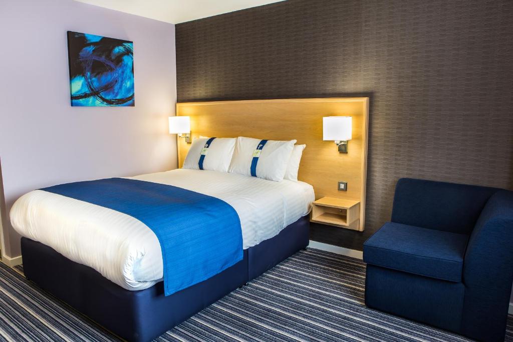 um quarto de hotel com uma cama e uma cadeira em Holiday Inn Express Manchester Airport, an IHG Hotel em Hale