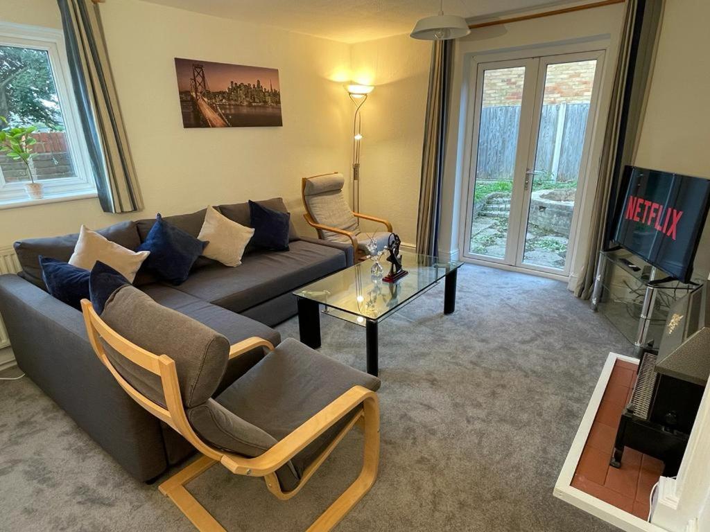 een woonkamer met een bank en een tafel bij 3-bedroom home with free parking in Canterbury