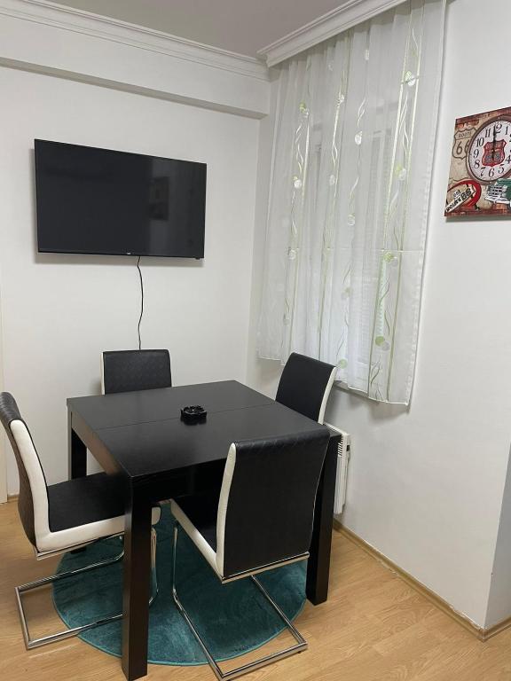a black dining room table with chairs and a flat screen tv at SIMIKIC Z in Bijeljina