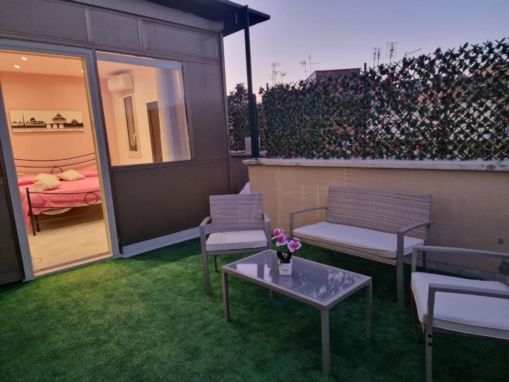 a patio with two chairs and a table and a bedroom at Saint Peter Vatican City confortable Apartament Stellasia casa vacanza in Rome