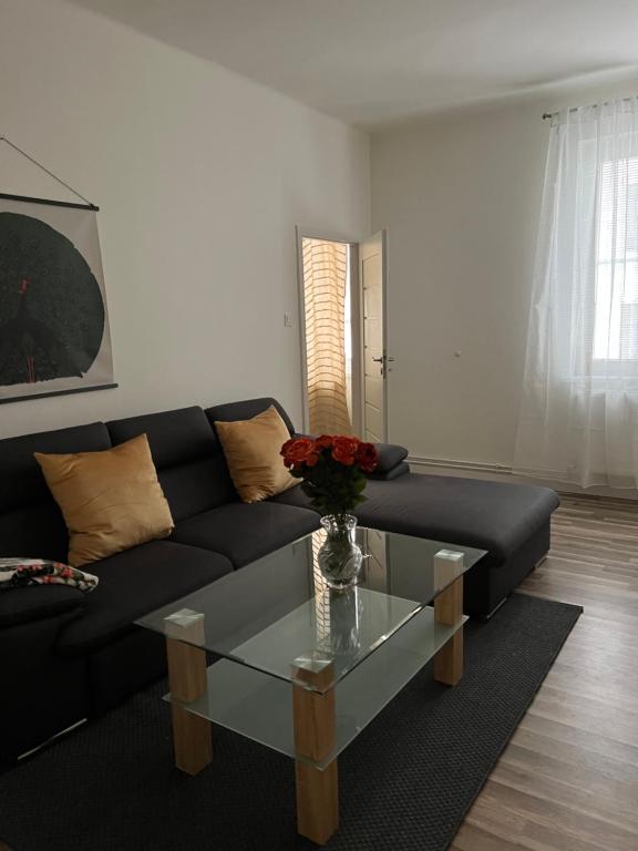 a living room with a black couch and a glass table at Lovely flat in the city center self-check in Bratislava