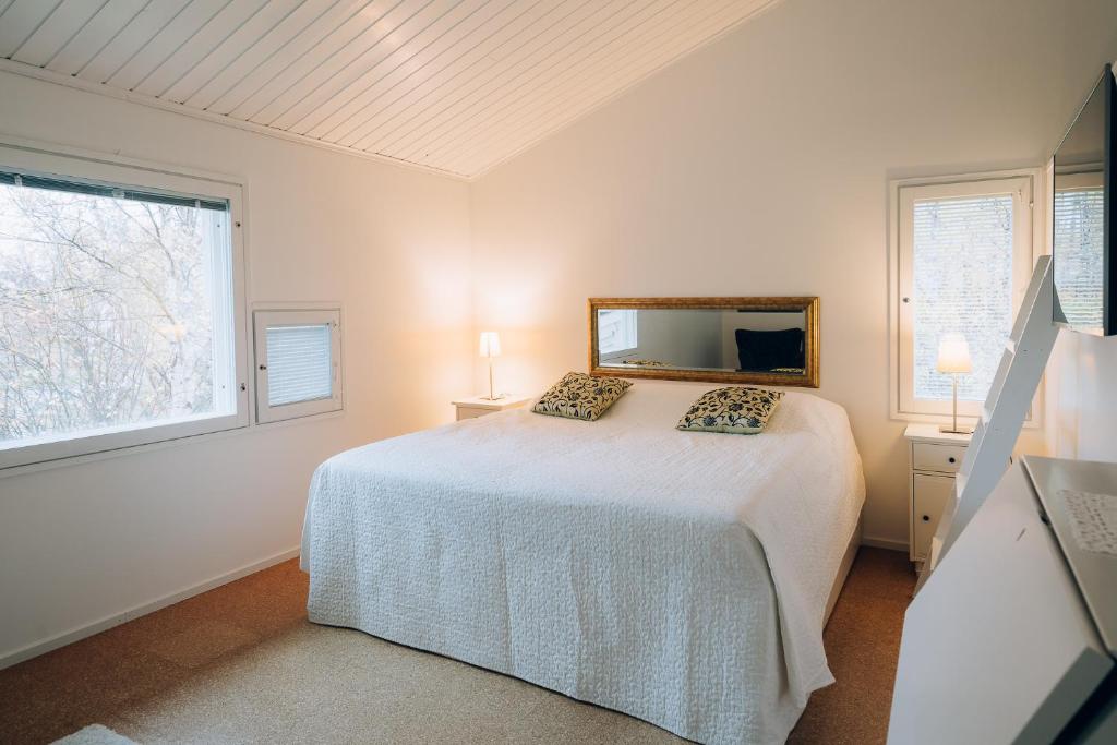 a white bedroom with a bed and a mirror at Villa Snow White in Rovaniemi