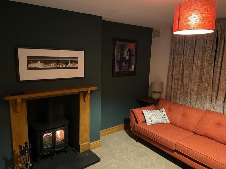 ein Wohnzimmer mit einem Sofa und einem Kamin in der Unterkunft Cwmbach Cottage nr Hay on Wye in Glasbury