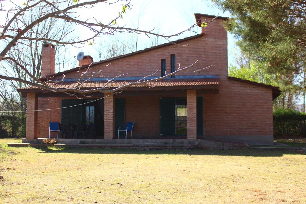 a red brick house with chairs in a yard at Vista del sol in Villa Ciudad Parque
