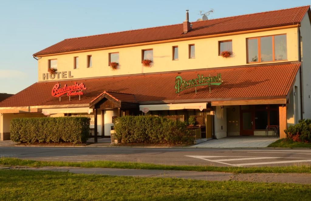 um edifício de motel com um parque de estacionamento em frente em Hotel & restaurant SIGNAL em Pardubice