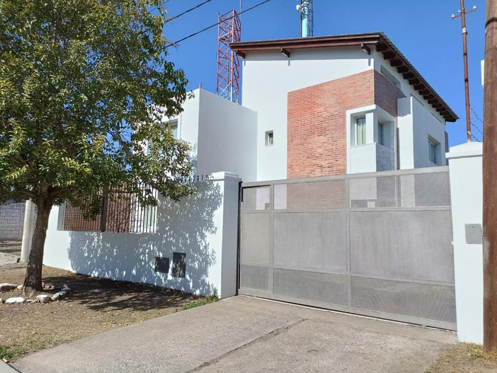 una casa blanca con una valla y un árbol en Givarolif en Salta