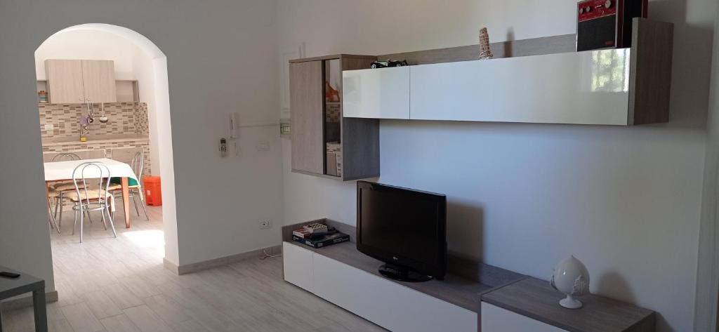 ein Wohnzimmer mit einem TV und einer Küche in der Unterkunft Casa vacanze Agrumeto in Latiano