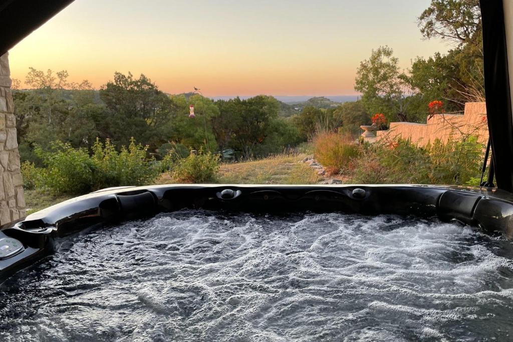 a hot tub filled with water in a yard at On Top of the World in New Braunfels