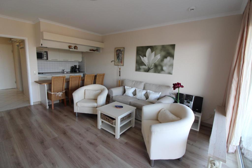 Una sala de estar con un sofá y sillas y una mesa. en Haus Norderhoog Wohnung 54, en Westerland