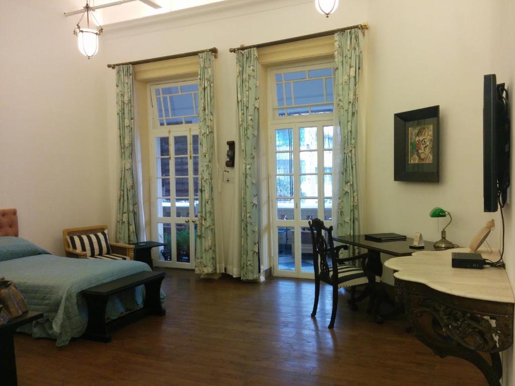 a bedroom with a bed and a table and chairs at The Harrington Residency in Kolkata