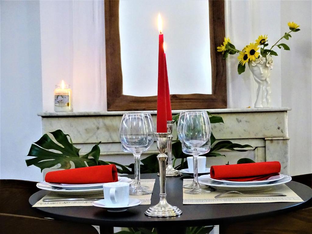 einen Tisch mit einer roten Kerze und Weingläsern in der Unterkunft BLUE FOUNTAIN Luxueux Studio Aix Centre Historique -WIFI-SMART TV- in Aix-en-Provence