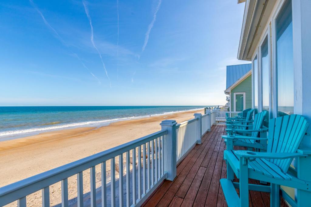 a balcony with blue chairs and the beach at NTB104 Seas Escape in North Topsail Beach