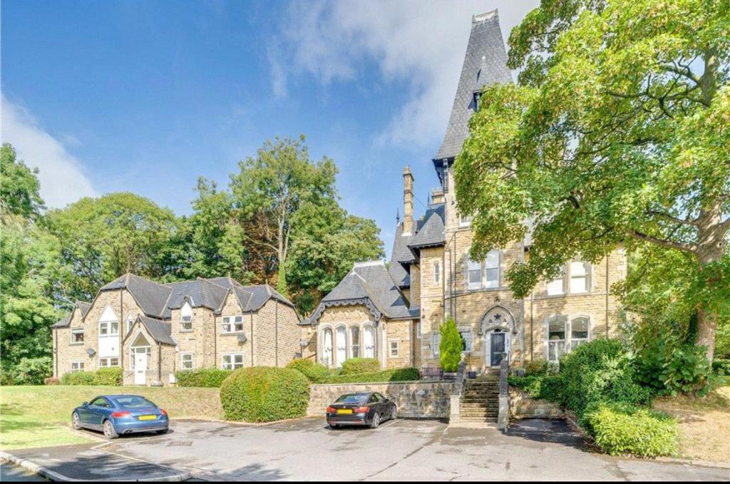 a large house with cars parked in front of it at Headingley Excellent 1 bedroom apartment in Leeds