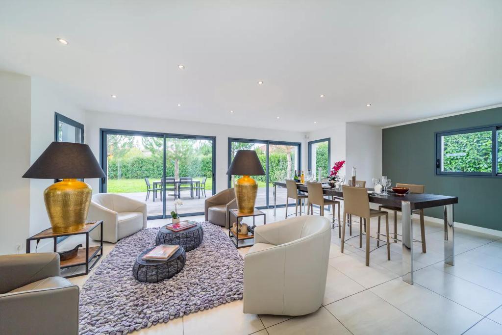 ein Wohnzimmer mit einem Tisch und einem Esszimmer in der Unterkunft Dream 5BD Villa for Families - Geneva Centre 14KM by GuestLee in Veigy-Foncenex