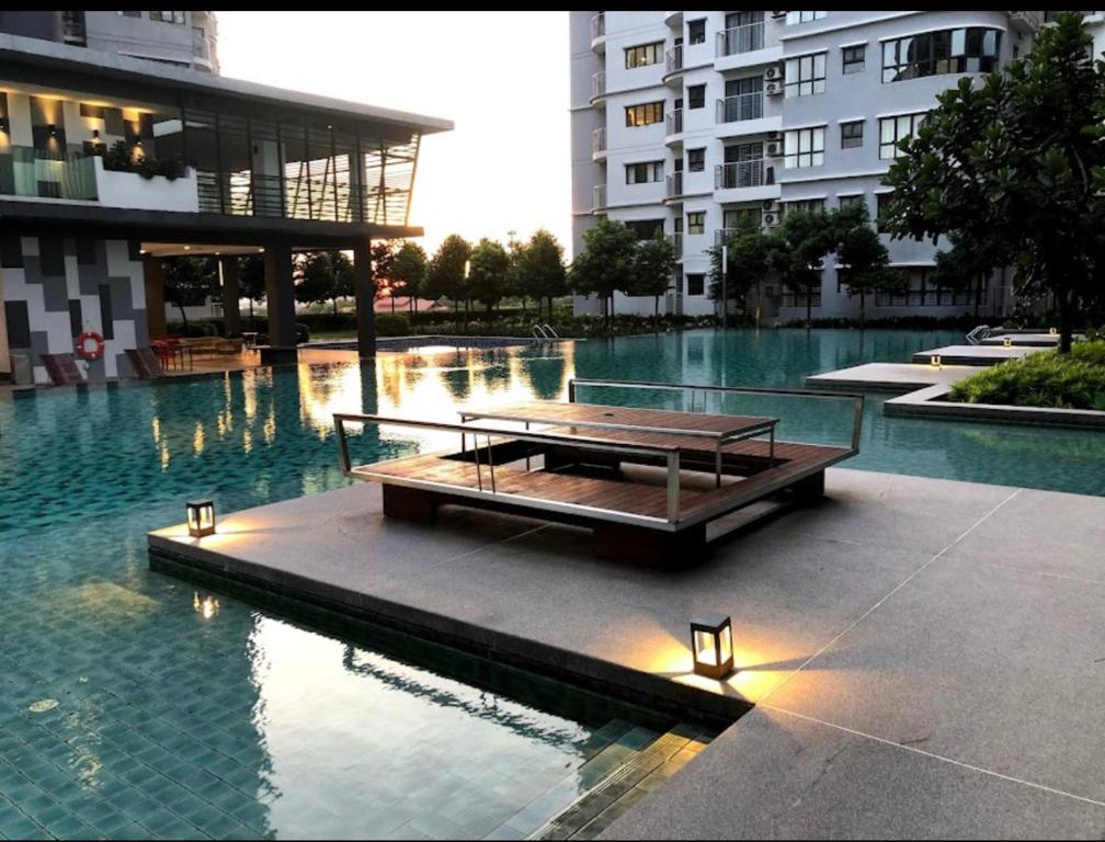 uma mesa de piquenique no meio de uma piscina num edifício em Homestay Damansara 2BD 2Parking em Petaling Jaya