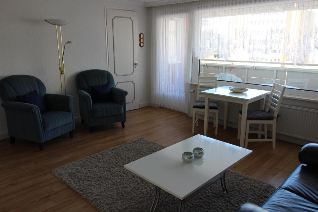 ein Wohnzimmer mit einem Sofa, einem Tisch und Stühlen in der Unterkunft Haus Nordseeresidenz Wohnung 63 in Westerland