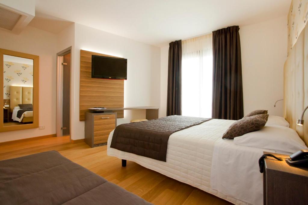 a hotel room with a bed and a television at Hotel Marco Polo in Lido di Jesolo