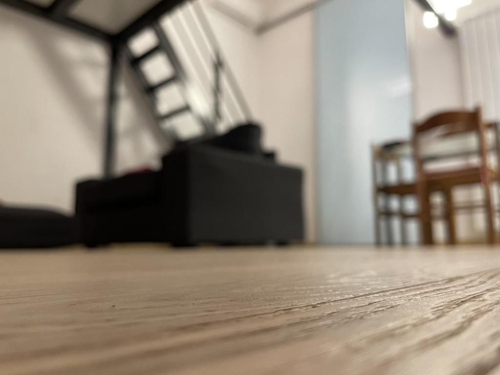 Apartment Typex في ميلانو: غرفة فارغة مع أرضية وكراسي خشبية