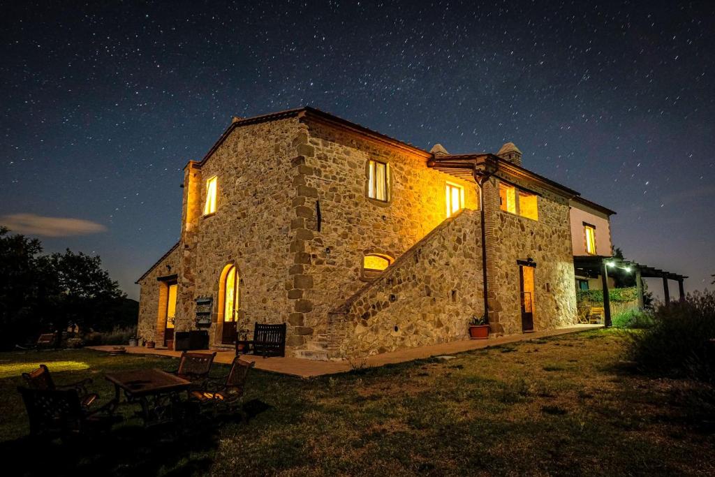 uma casa de pedra à noite com um céu estrelado em agriturismo Poggio Monte Saturnia em Saturnia