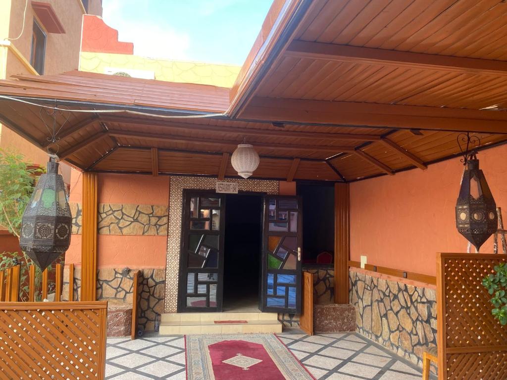 une maison avec une terrasse couverte et un toit en bois dans l'établissement Hotel la renaissance tata, à Tatta