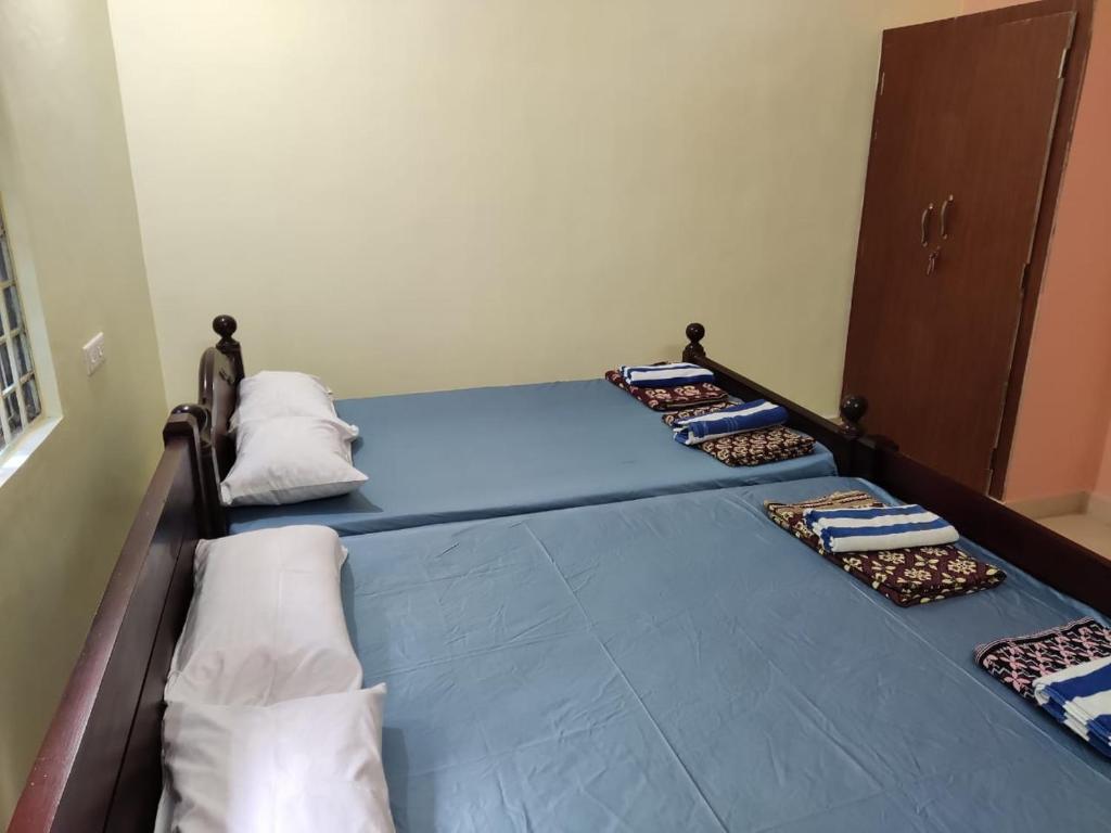 a row of beds in a room with pillows at Sri Sai Farm House in Puducherry